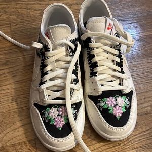 Special edition Nike Dunks with flower and bird decorations.